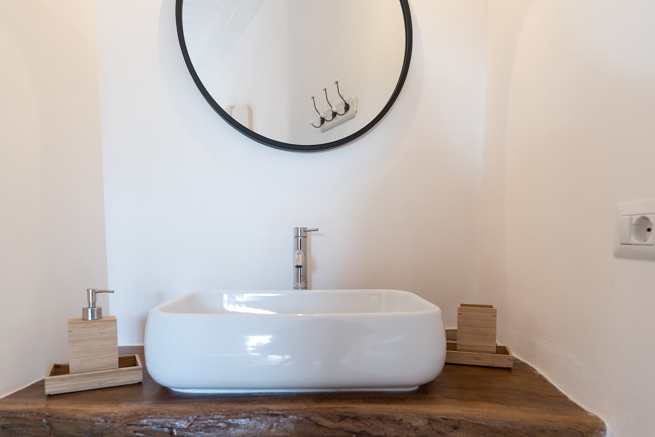 A basin set on a solid-wood counter in one of the bathrooms