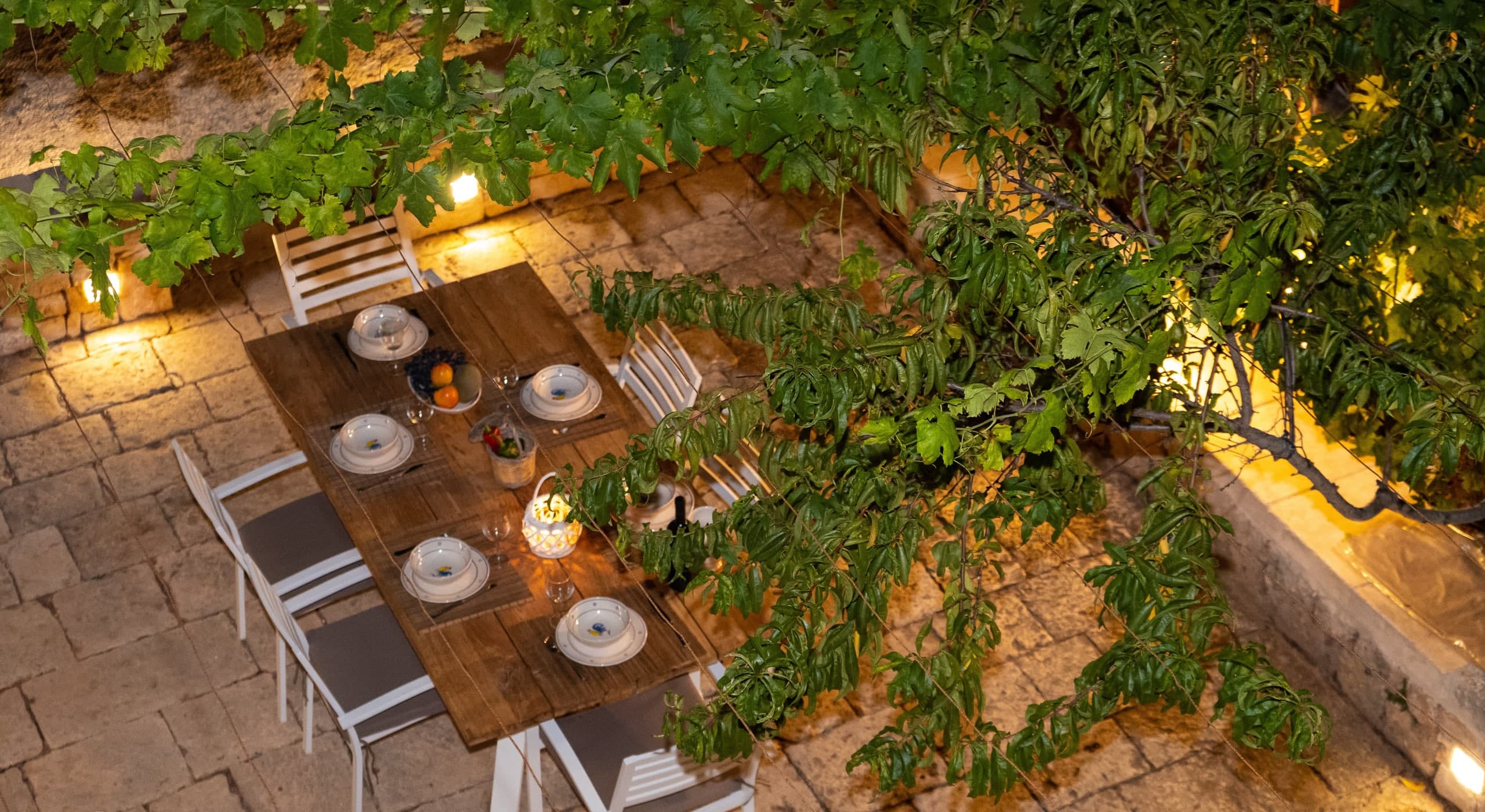 Looking down on the lit terrace table, at nightfall