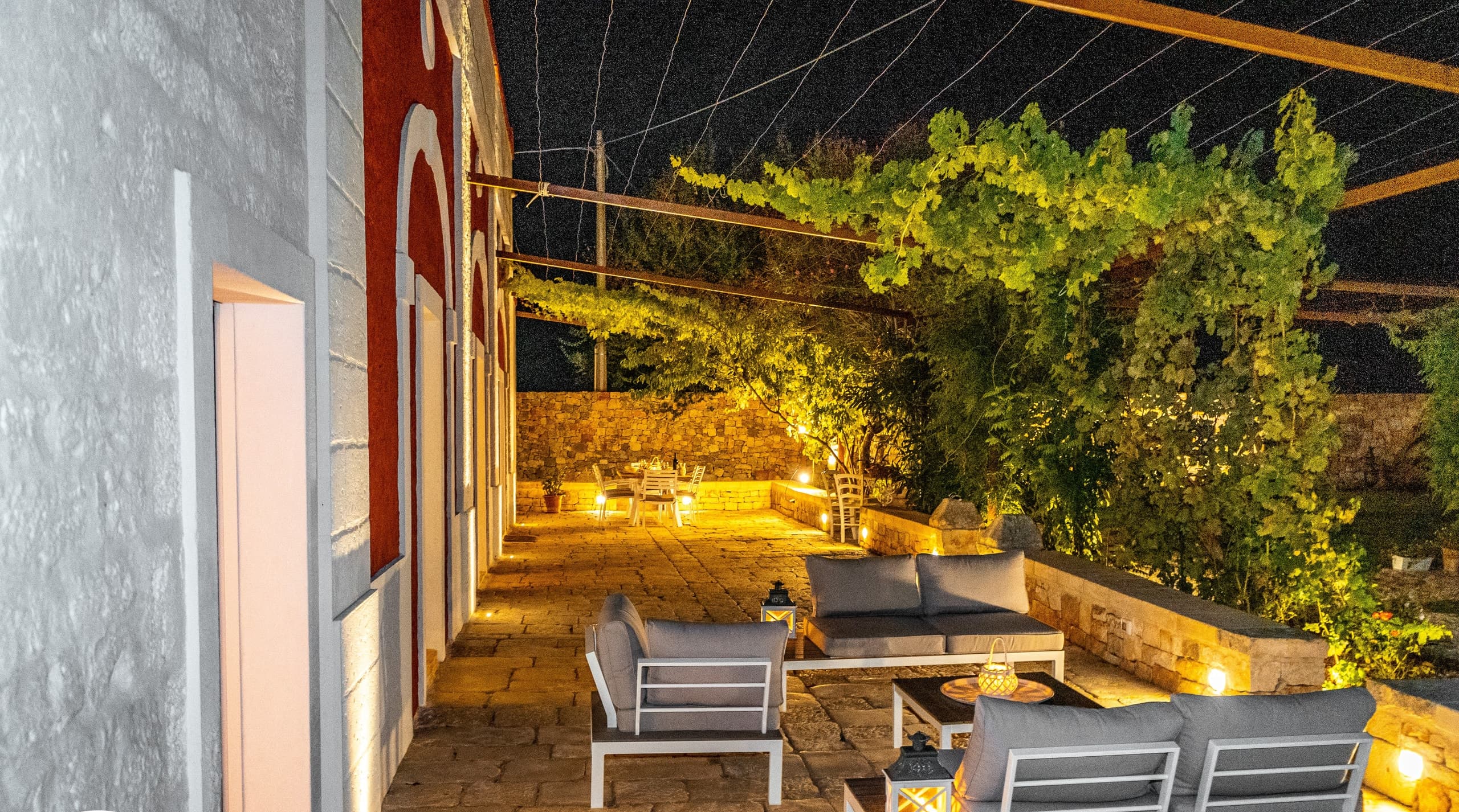 The terrace lounge at dusk, lanterns lit facing the countryside